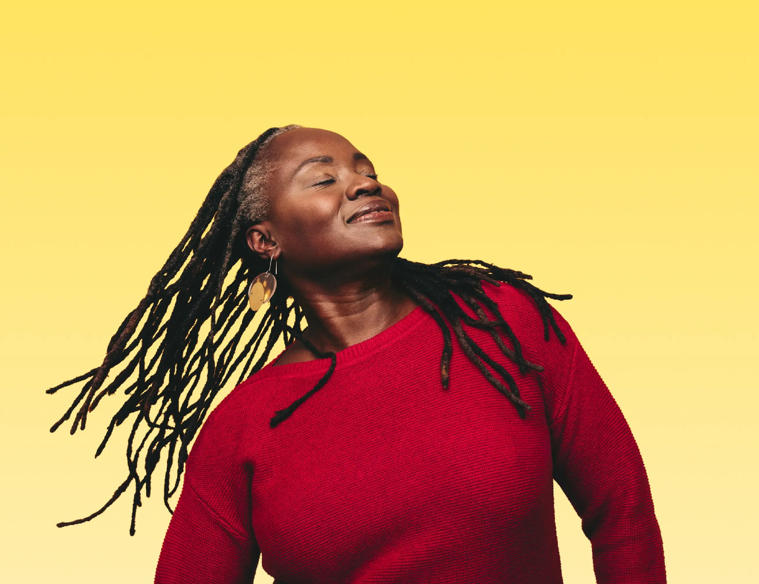 lady with black hair in dreds wearing a red sweater