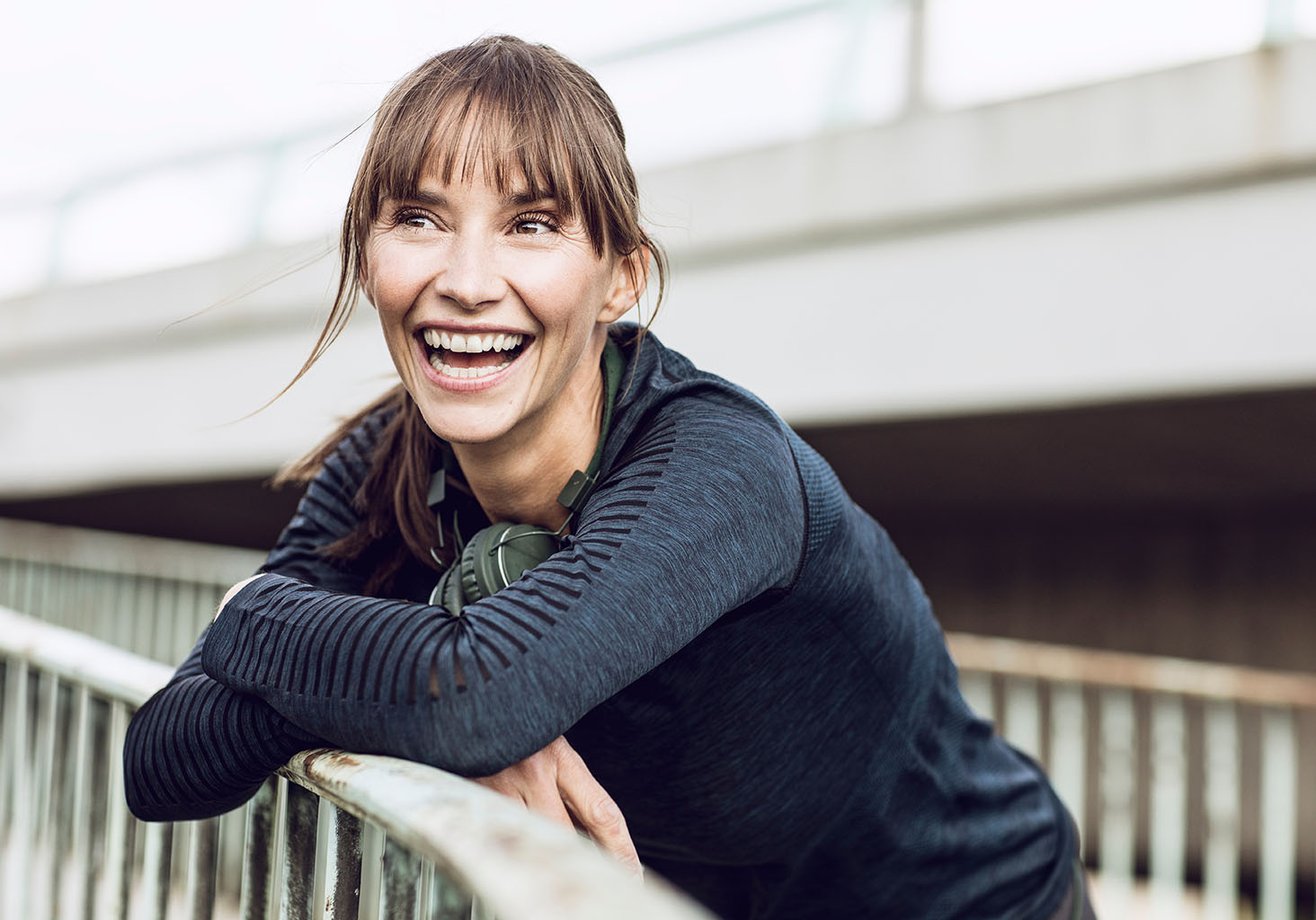 smiling woman leaning on bridge