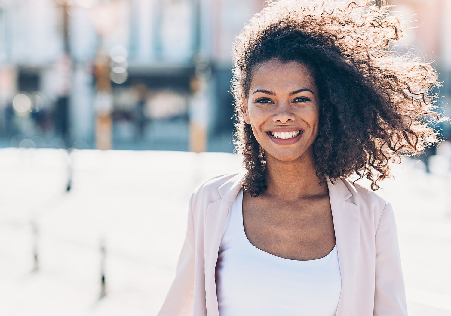woman smiling wearing a pink sweater