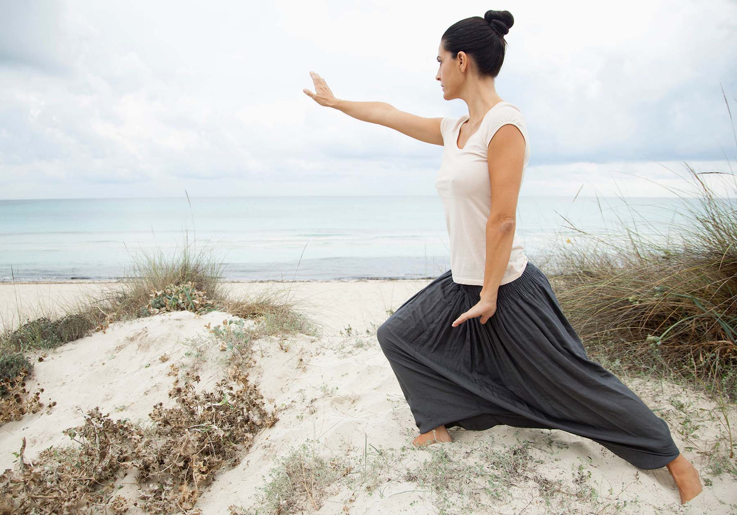 woman doing yoga on the beach