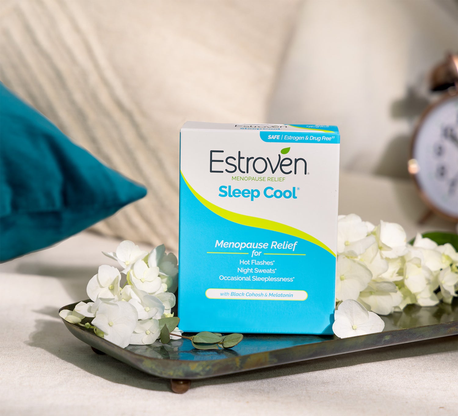 Estroven Sleep Cool product box on top of a silver platter with white flower petals
